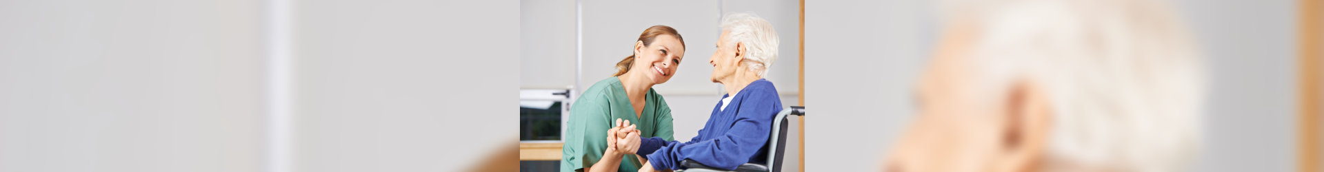 caregiver holding hands with elderly woman in a wheelchair